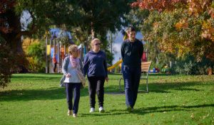 two ladies and a man walking through a park respite melbourne